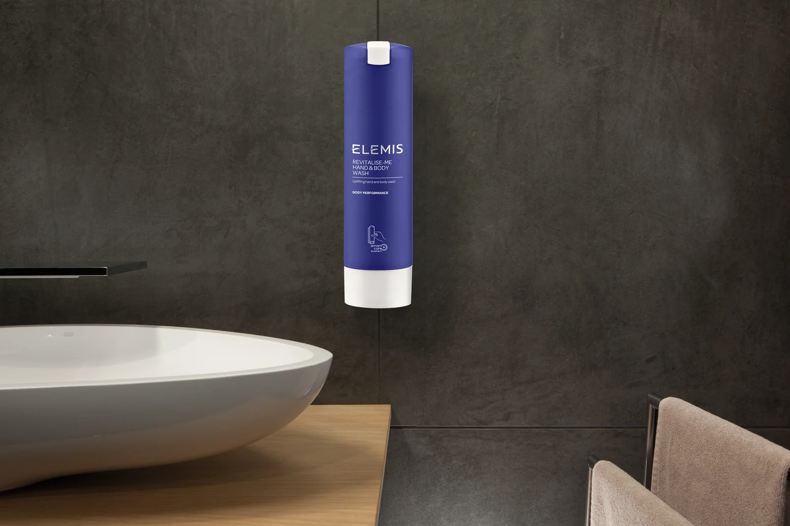 Blue Elemis SmartCare dispenser mounted on a bathroom wall above a basin