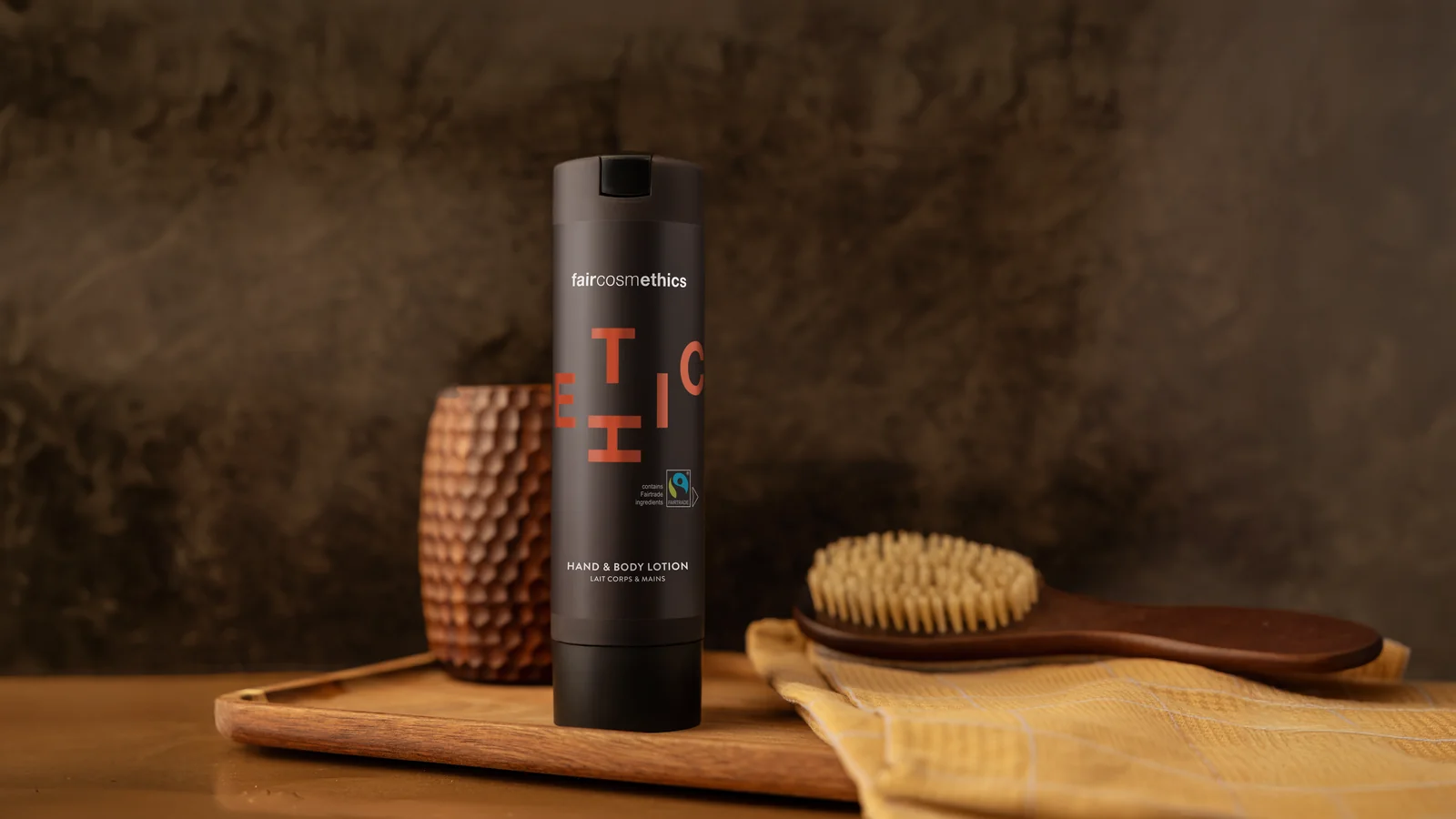 Faircosmethics bottle next to a wooden brush on a wooden table