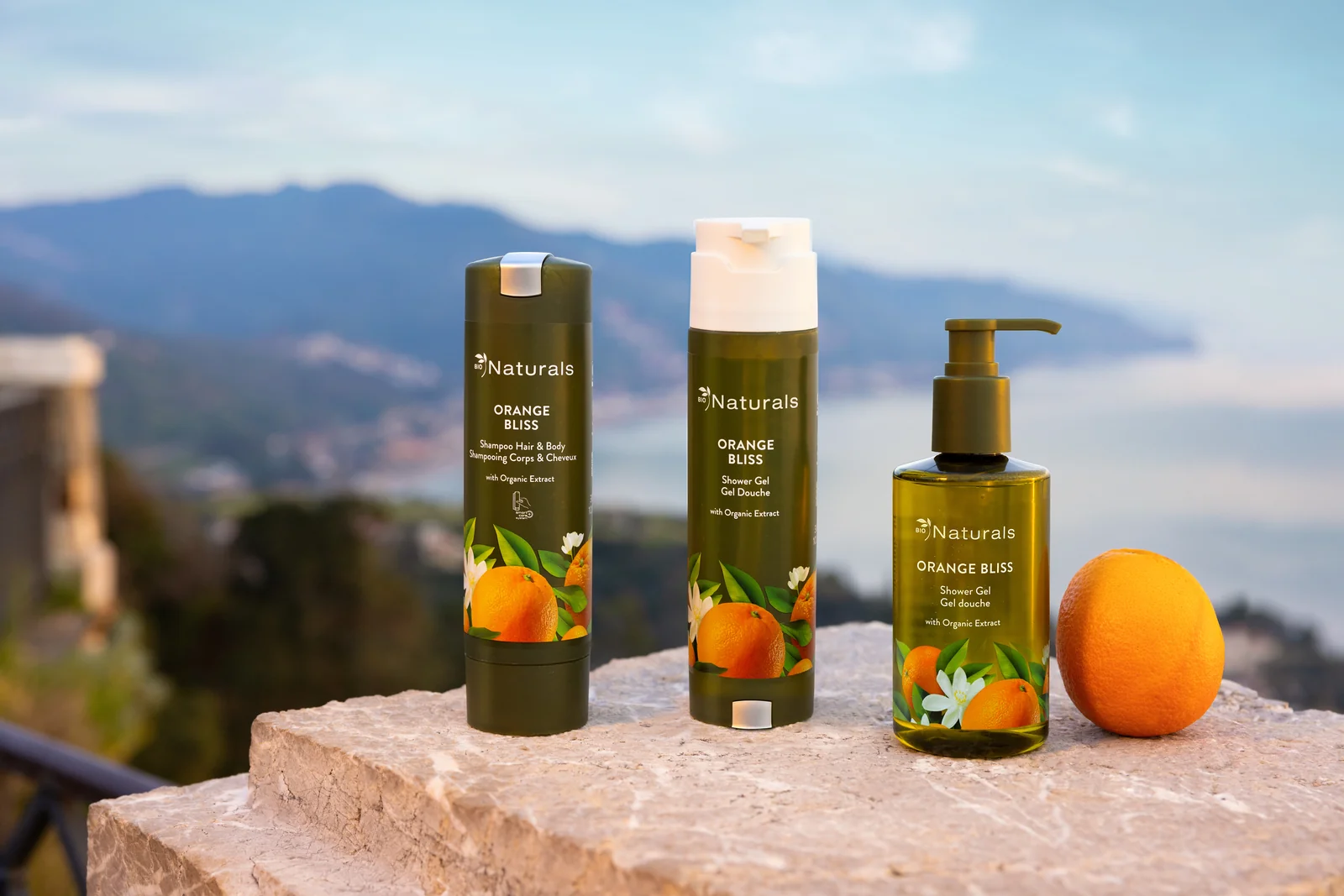 Naturals Orange Bliss bottle on a terrace overlooking the sea