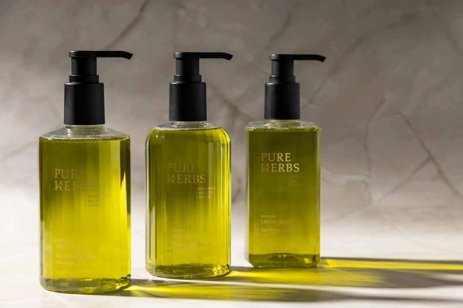 Trei flacoane Pure Herbs cu pompă, în lumină caldă